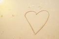 Heart drawn on beach sand at the sea Royalty Free Stock Photo