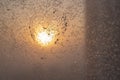 A heart drawn on a frozen winter window at sunset.