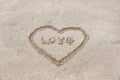 heart drawn on the sand on the beach stick in the center inscription love Royalty Free Stock Photo