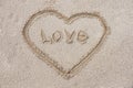 heart drawn on the sand on the beach stick in the center inscription love Royalty Free Stock Photo
