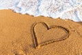 Heart drawn in the sand on the beach at sunset. Heart shape. Heart symbol. Love. Sea foam Royalty Free Stock Photo
