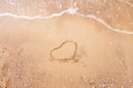 Heart drawn on a sand of beach with the wave of the sea. Free space for your text. Summer holiday concept. Romantic love Royalty Free Stock Photo