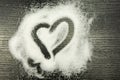 Heart drawn on scattered sugar.