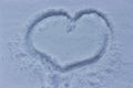 Heart drawn on the snow, winter cold weather. Love despite snowfall and cold. Tender feelings squabble a blizzard Royalty Free Stock Photo
