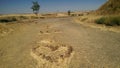 Heart drawn with stones on a dirt road.