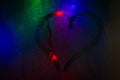 Heart drawn on wet glass. The lights of the night city through the wet glass Royalty Free Stock Photo