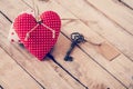 Heart fabric and vintage key with tag on wood table background. Royalty Free Stock Photo