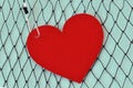 Heart on fish hook on fishing net - Love concept Royalty Free Stock Photo