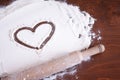 heart on flour and a wooden rolling pin