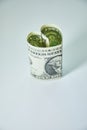 Heart folded from one dollar bill over gray background with copy space. Concept image of money love