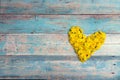 Heart form from yellow dandelions with copy space on old turquoise wooden background. Royalty Free Stock Photo