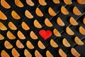 Heart and fruit marmalade in the form of mandarin lobules lie on dark painted boards. The combination of black, orange and red. Royalty Free Stock Photo