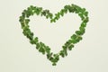 Heart of green clover leaves on light background, flat lay. Space for text Royalty Free Stock Photo