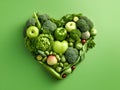 Heart of green fruits and vegetables isolated on light green background. Green life concept and healthy eating lifestyle. Shape of Royalty Free Stock Photo