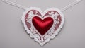 heart on a grey background A red silk heart with a white lace border on a white background. The heart is smooth and shiny, Royalty Free Stock Photo