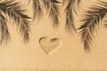 Heart hand-drawn, palm tree branch shadow on sand tropical beach. valentines day. Beach holiday concept, travel, summer. Flat lay. Royalty Free Stock Photo
