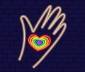 Heart in hand of neon in rainbow color. LGBT neon sign vector design template. Gay Pride neon element. LGBT pride symbol Royalty Free Stock Photo