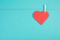 A heart hanging on a clothing line, blue colored background, empty copy space, symbol of love Royalty Free Stock Photo