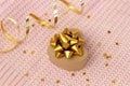 Heart hape present box with a gold bow on a pink background knitted sweater with golden stars confetti and serpentine. Flat style Royalty Free Stock Photo