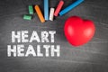 Heart health. Colored chalk and red rubber heart on the blackboard