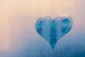 The heart icon on foggy window. Abstract blue background. Pattern of wet glass, cool texture in rainy day. Symbol of love. Romanti