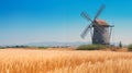 Wooden windmill standing amidst golden wheat fields under a clear blue sky