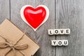 Heart . Inscription from wooden cubes LOVE YOU and a box with a gift on a gray background. Holiday concept - Valentine`s Day Royalty Free Stock Photo