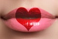 Heart kiss on the Lips. Beauty full lips with heart shape paint. Valentines Day. Beautiful make-up. Lipstick and lipgloss Royalty Free Stock Photo