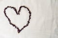 Heart laid out of female beautiful beads, necklaces of brown dark stones, amber against a background of beige fabric Royalty Free Stock Photo