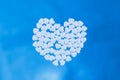 Heart laid out from tablets in the form of hearts on a blue background