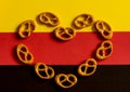 Heart Laid silhouette of many small pretzels on a background of the German flag colors