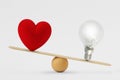 Heart and light bulb on scale - Concept of brain priority over heart in life Royalty Free Stock Photo