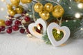 Heart lights, fir tree branch and red and golden berries on white. Greeting card for Christmas, New year and Valentines day. Royalty Free Stock Photo