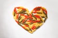 Heart lined with colored pasta on a white background Royalty Free Stock Photo