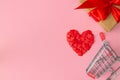 Heart lined with small red hearts with gift wrapped in craft paper and red ribbon and shopping cart on pink background Royalty Free Stock Photo