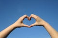 Heart of love with hands in blue sky Royalty Free Stock Photo