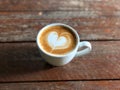 Piccolo coffee with heart latte art on rustic wood table