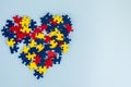 Heart made from blue, yellow, red puzzles on light blue background. World autism awareness day concept. Top view, copy Royalty Free Stock Photo