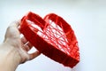 Heart made of cardboard and with red threads in a man& x27;s hand.