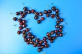 Heart made of cherries. Blue background Close-up. Summer june fruit harvest. Free copy space Royalty Free Stock Photo