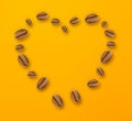 Heart made of coffee beans isolated on yellow background Royalty Free Stock Photo