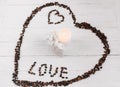 Heart made of coffee beans, white bag with gift and candle Royalty Free Stock Photo