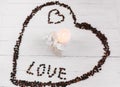 Heart made of coffee beans, white bag with gift and candle Royalty Free Stock Photo