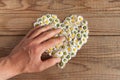 Heart made of daisies flowers in wooden background, covered by a Royalty Free Stock Photo