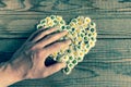 Heart made of daisies flowers in wooden background, covered by a Royalty Free Stock Photo