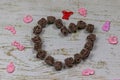 Heart made of dark roses with toys. On wooden background, photo bokeh. Feast of love, Valentine`s Day.