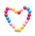 Heart made of different candies on white background