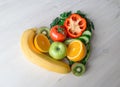 Heart made from different fruits and vegetables on light wooden table Royalty Free Stock Photo