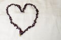 Heart made of female beautiful beads, necklaces of brown dark stones, amber against a background of beige fabric Royalty Free Stock Photo