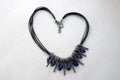 Heart made of female jewelry, necklaces with black threads, blue jewels, diamonds, diamonds in the shape of a heart